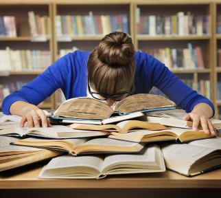 אילוסטרציה: צעירה מניחה ראש בייאוש על ערימת ספרים בספרייה