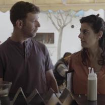 גבר ואישה מסתכלים אחד על השני ועומדים ליד שולחן אוכל