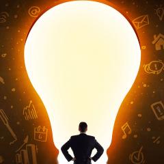 בתמונה: אדם מהגב מתבונן למנורה מאוד גדולה על רקע קיר עם איורים