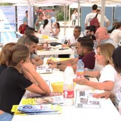 שולחן ומסביבו מתעניינים ויועצים ביום הפתוח בספיר