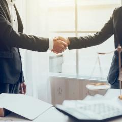 אילוסטרציה: אישה ואיש לוחצים ידיים לצד מאזניים שמסמלות צדק