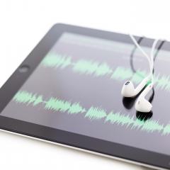 אילוסטרציה: אוזניות על טאבלט עם סימני סאונד