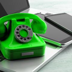 אילוסטרציה: טלפון ירוק ישן על מחשב וליד ניידים