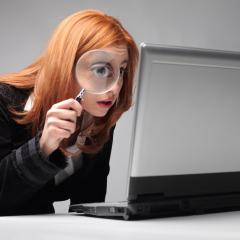 אילסטרציה: אישה צעירה מסתכלת דרר זכוכית מגדלת במחשב