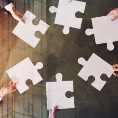 אנשים מחזיקים חתיכות פאזל לבנות