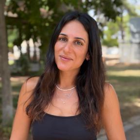 אישה עומדת על רקע עצים