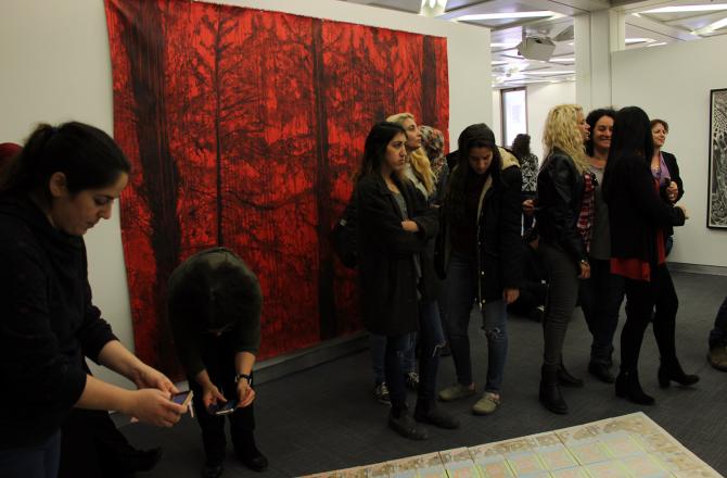 קהל בתערוכה על רקע ציור של ד"ר זיוה ילין
