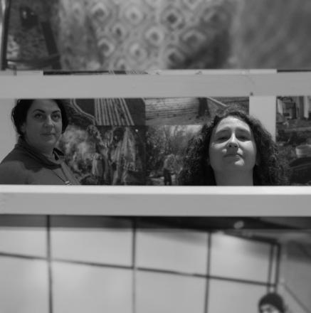 צילום שחור לבן של שתי נשים מבעד לחלון מטבח