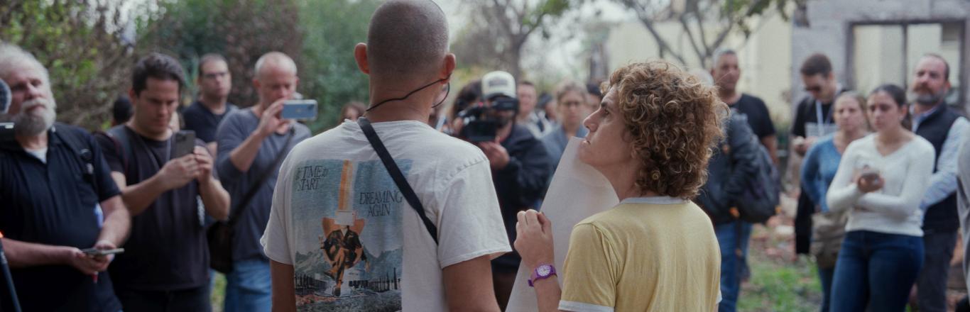 זוג עומד מול קבוצה של כתבים - לחצו לפתיחת הסרטון בחלונית