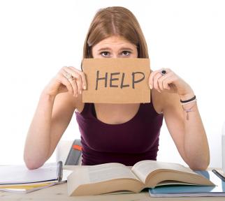 סטודנטית ליד ספר בידה שלט "עזרה"