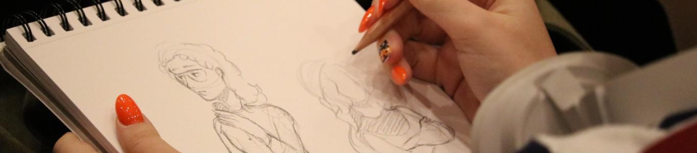 אישה מציירת סקיצה במחברת