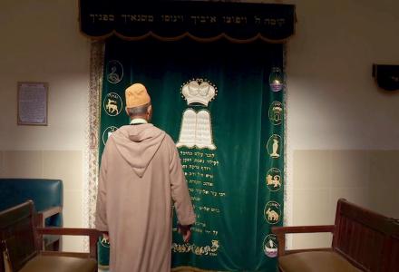 בן אדם עם הגב למצלמה בבית כנסת
