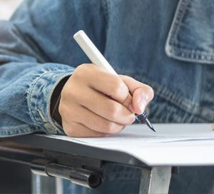 סטודנט במעיל ג'ינס כותב בכיתה
