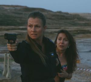 שוטרת עם נשק מגינה על אישה 