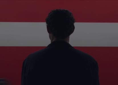 גבר עומד מול רקע אדום לבן